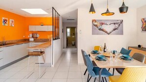 A modern kitchen with a wooden countertop and a dining area with a table set for four. - Villa "Dolce Vida" golf / lake / spa 6p (Villeneuve-de-la-Raho)