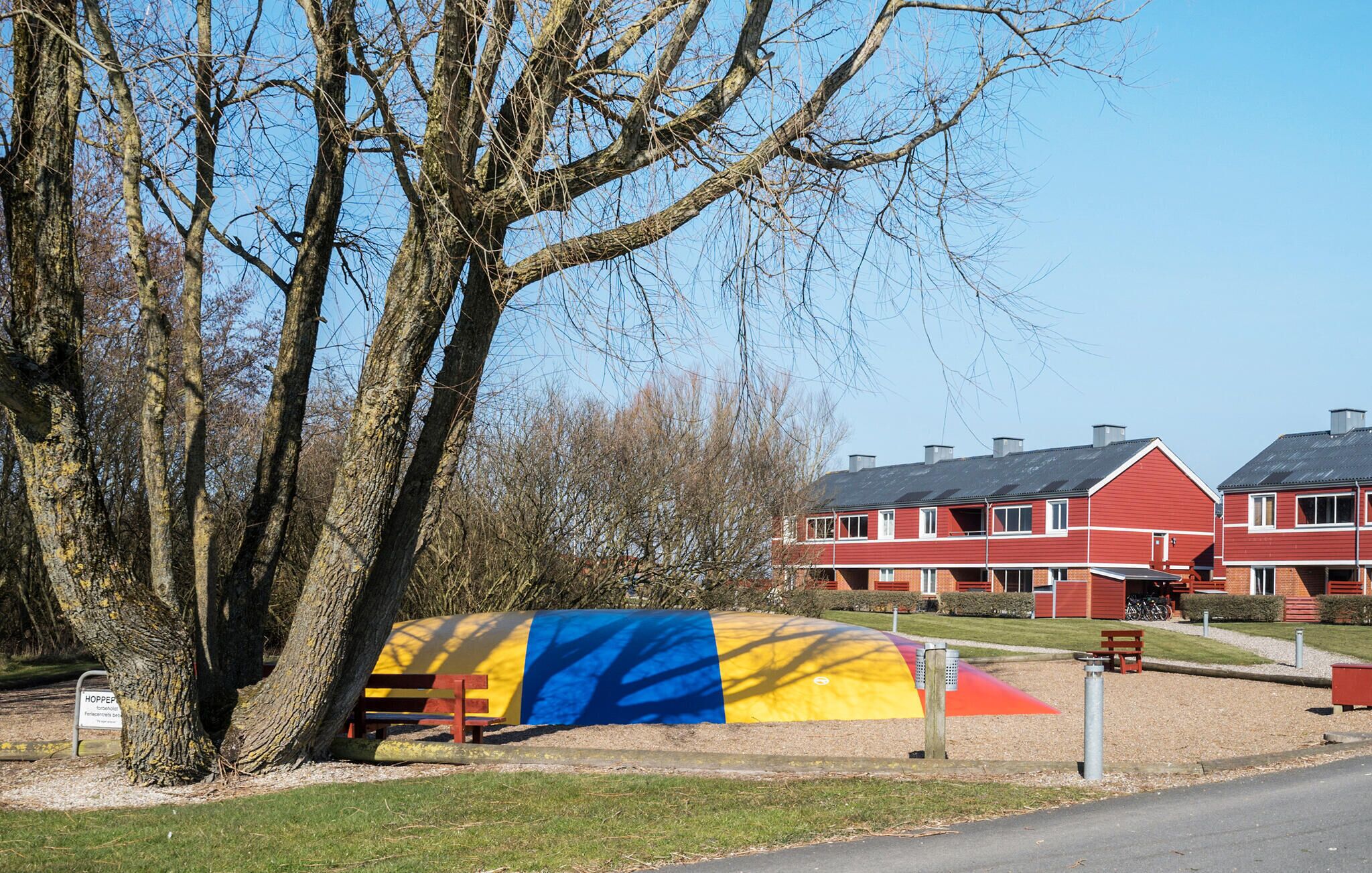 A red residential building with a sloped roof and multiple chimneys.