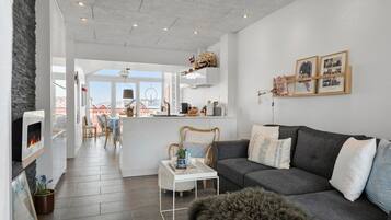 Un salon moderne avec une cheminée, un canapé et un coin repas offrant une vue agréable.