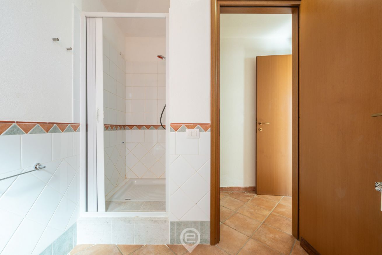 A bathroom with a shower, a toilet, and a sink.