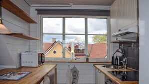 A compact kitchen with a large window, wooden countertops, and modern appliances. - Pet friendly apartment in Degeberga (Degeberga)