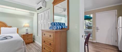 Un dormitorio con cama, mesita de noche, cómoda y espejo.