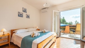 Un dormitorio con cama, mesita de noche y vistas al exterior.