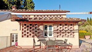 A small building with a tiled roof and a brick wall. There is a table and chairs outside. - Stunning home in Montelupo Fiorentino (Montelupo Fiorentino)