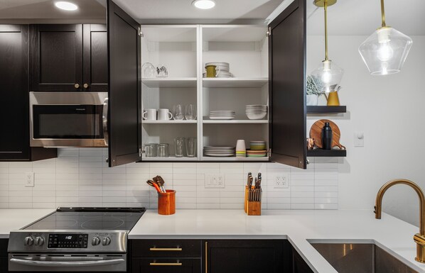 A modern kitchen with dark cabinetry, a stainless steel oven, a built-in microwave, and a white countertop. - Elk Park Retreat - A Comfy & Stylish Mt. Hood Cabin - Hot Tub, Dogs OK (Mount Hood Village)