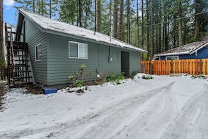 A two-story cabin with a wooden deck and a snow-covered ground. - Elk Park Retreat - A Comfy & Stylish Mt. Hood Cabin - Hot Tub, Dogs OK (Mount Hood Village)