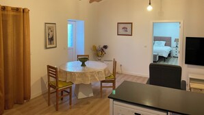 A cozy room with a wooden ceiling, a dining table with chairs, a bed, and a TV.