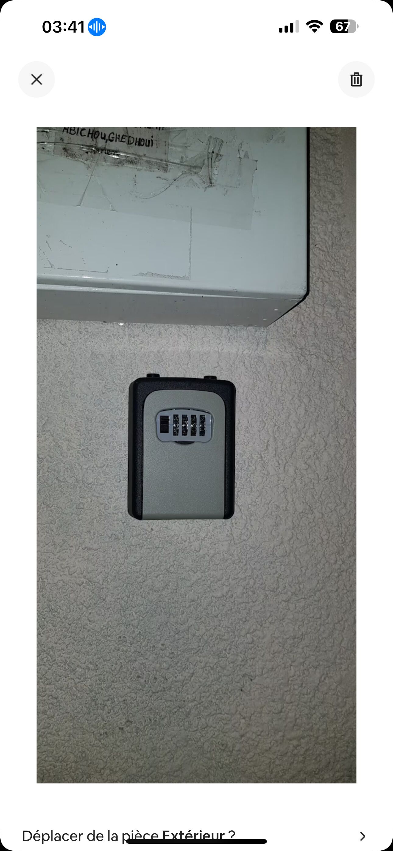 A small, gray electronic device with a keypad on a textured surface.