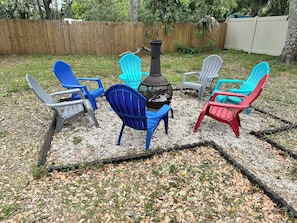 A patio area with outdoor furniture arranged around a central fire pit. - Upstairs 2BR · Fire Pit Yard · Laundry · Fast WiFi · Monthly Deals · Near Beach (Daytona Beach)
