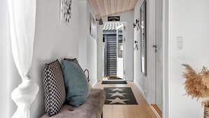 A hallway with a sofa, pillows, a star-patterned rug, and a welcome sign. - Nice home in Græsted with WiFi (Græsted)