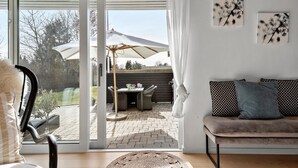 A modern living room with a sliding glass door leading to an outdoor patio area. - Nice home in Græsted with WiFi (Græsted)