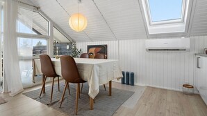 A dining area with a table, chairs, a hanging light, and a painting on the wall. - 2 bedroom beautiful home in Børkop (Børkop)