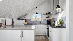 A modern kitchen with white cabinets, a large island, a window with a view, and pendant lighting. - 2 bedroom beautiful home in Børkop (Børkop)