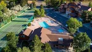 Zona residencial con cancha de tenis, piscina y casas.