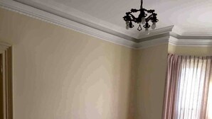 Una sala de estar con un sofá, sillones, una mesa de centro, una lámpara y una araña.