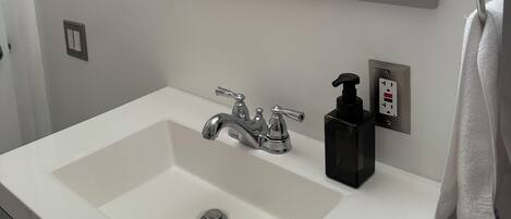 Een haardroger, handdoeken, zeep, toiletpapier