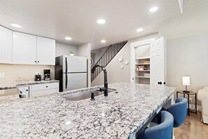 Enjoy cooking in this well-equipped kitchen with a sink and refrigerator.