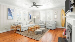 A living room with a white sofa, two armchairs, a coffee table, and a fireplace. - CB Surf House|Charming Beach House 2mins to Beach (Carolina Beach)
