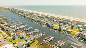 An aerial view of a coastal marina with multiple docks and boats, surrounded by residential buildings and a beach. - CB Surf House|Charming Beach House 2mins to Beach (Carolina Beach)