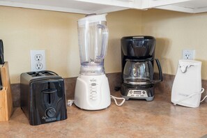 A kitchen with a toaster, a blender, a coffee maker, and a Proctor 39 appliance. - Relaxed Lake-Access Condo with Outdoor Pool, Mini Golf, Pickleball & Free Attraction Tickets (Kimberling City)