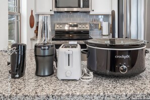 A kitchen with a Ninja blender, a toaster, and a crockpot.