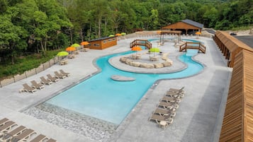 A resort with a swimming pool, lounge chairs, and a wooden building.