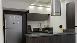 A modern kitchen with a built-in island, stainless steel appliances, and recessed ceiling lighting. - TH with private pool in Pampatar, Venezuela (Pampatar)