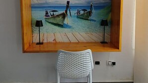 A wall with a framed tropical beach scene, a white chair, and a ceiling light fixture. - TH with private pool in Pampatar, Venezuela (Pampatar)