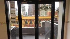 A view from a balcony with a no smoking sign, a Southgate building, and a yellow building with arched windows.