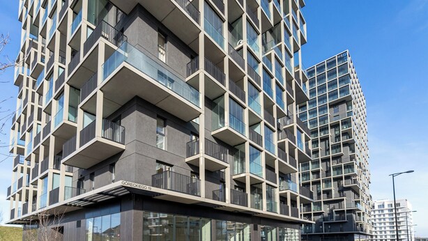 Un moderno edificio de gran altura con una estructura de balcones y amplias ventanas.