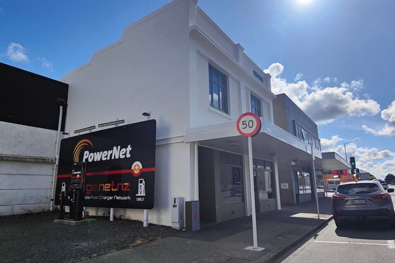 Een gebouw met een PowerNet bord en een snelheidslimiet van 50 km/u.