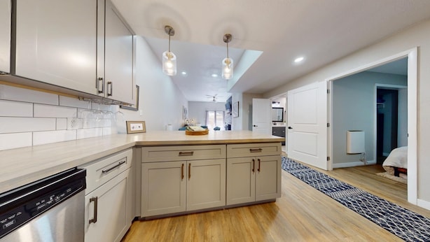 A modern kitchen with light wood cabinets, a central island, and pendant lighting. - Ski-in Ski-out  | Updated | High Ceilings | Gold Creek 204 (Angel Fire)