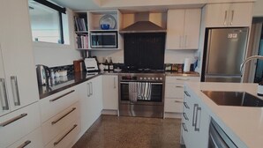 Une cuisine moderne avec des armoires blanches, des appareils en acier inoxydable et un comptoir en granit.