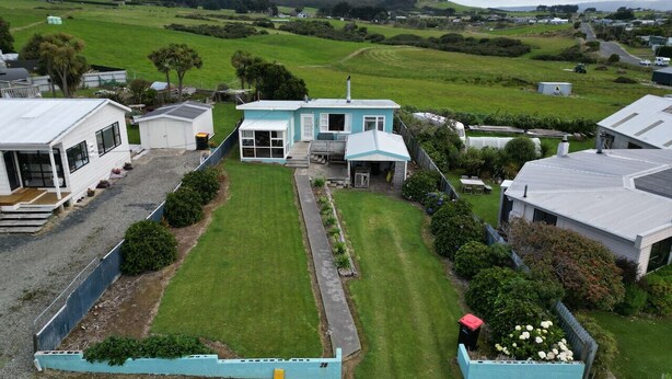 A residential property with a large lawn, a detached house, and a smaller building.