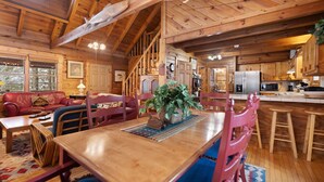 A spacious wooden cabin with a dining area, kitchen, and living room. - Dockside Cabin | RRG | Hot Tub | Kayaks | Fire Pit (Campton)