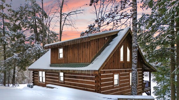 A wooden cabin with a steep roof, surrounded by snow-covered trees. - Dockside Cabin | RRG | Hot Tub | Kayaks | Fire Pit (Campton)