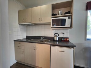 Een microgolfoven, kookgerei, borden en bestek, een eettafel