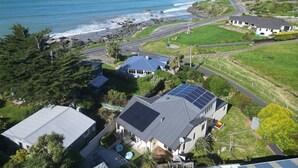 A coastal residential area with houses, a road, and a view of the ocean. - Riverton Helm`s Deep (Riverton / Aparima)