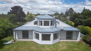 A modern two-story house with a sloped roof, large windows, and a well-maintained lawn. - Te Anau Dusky Delight (Te Anau)
