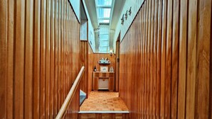 A narrow hallway with wooden paneling, a tiled floor, and a skylight at the end. - Te Anau Retro Retreat (Te Anau)