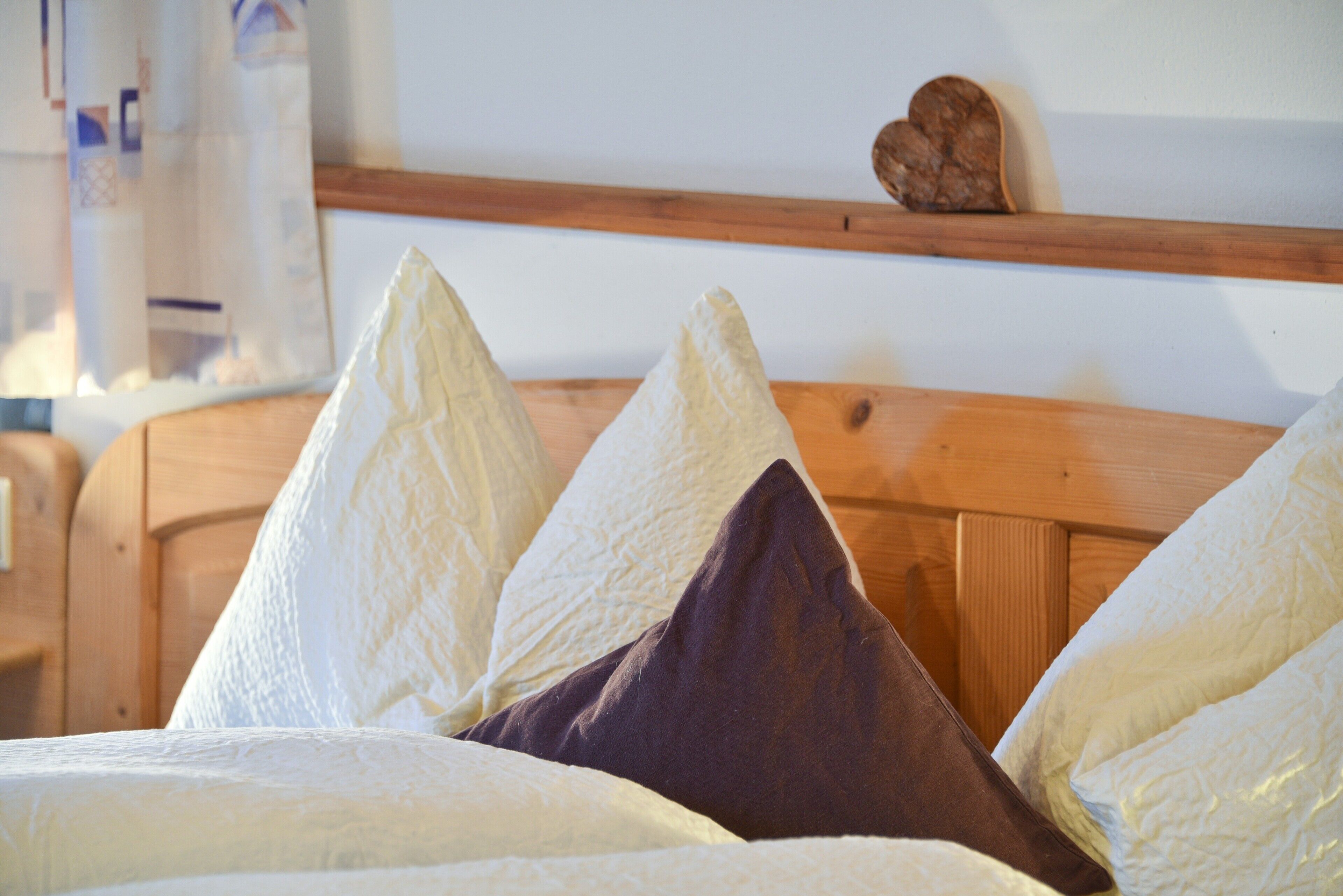 Ein Bett mit Kissen und einem Holzkopfende.