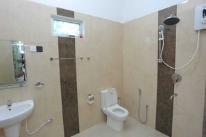 Une salle de bain avec des toilettes, un lavabo et une douche.