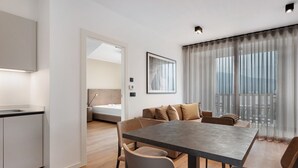 A modern hotel room with a dining area, a bed, and a large window with sheer curtains. - Apartment 'Maso Renner 4' with Mountain View, Wi-Fi and Air Conditioning (Laives)