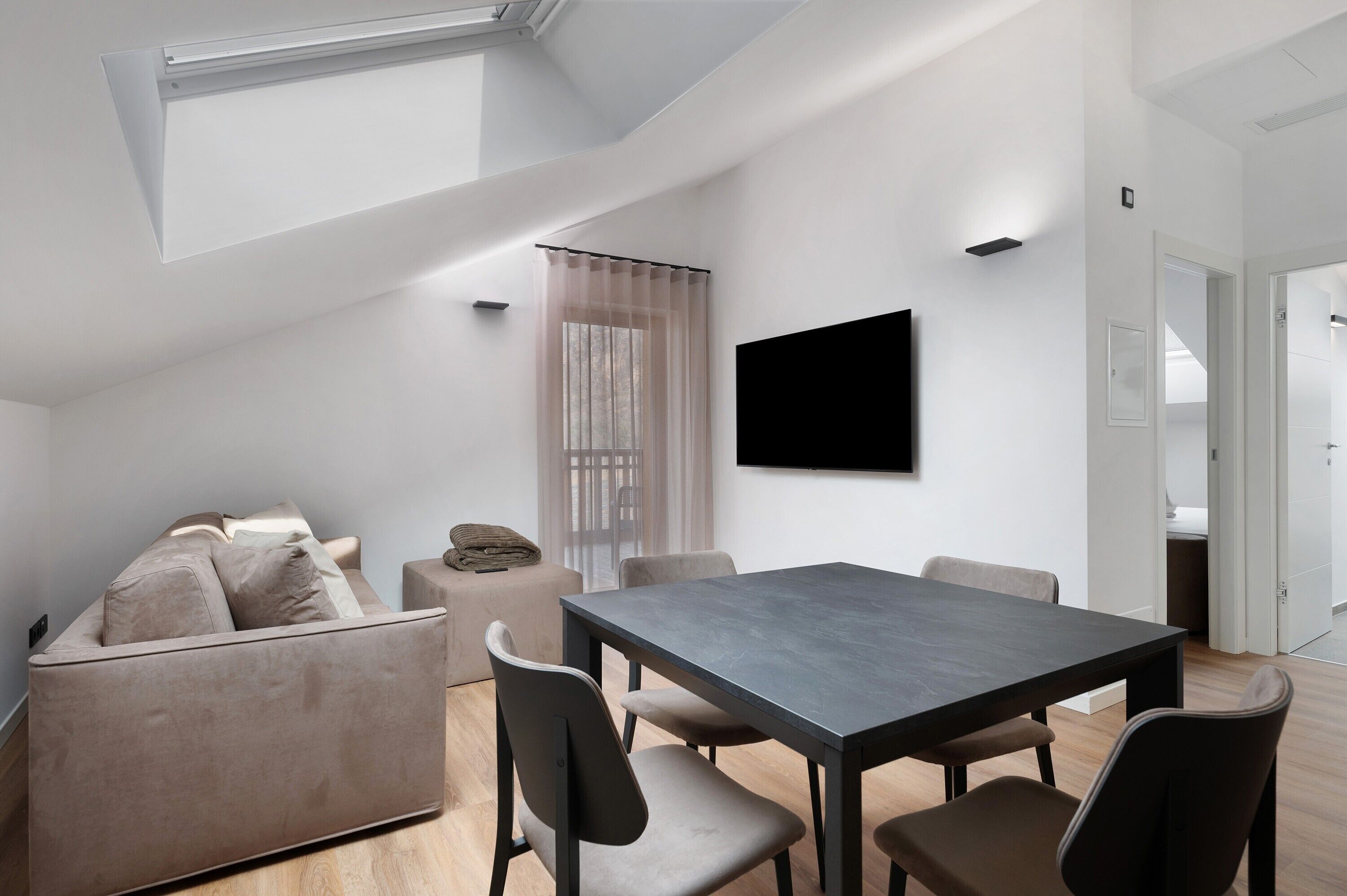 Un salon moderne avec un canapé, une table à manger et des chaises.