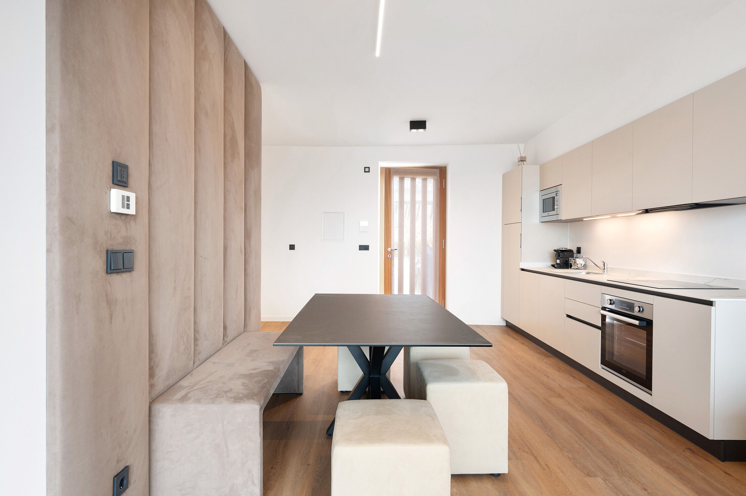 Een moderne keuken met een centraal eiland, een inbouwoven en een magnetron.