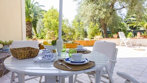 A white table with a woven basket, a white pitcher, and a blue and white plate set. - Apartment 'Ulivo' with Mountain View, Wi-Fi and Air Conditioning (Terrazze)