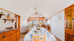Eine Küche mit Holzausstattung, einem Esstisch mit kariertem Tischlein und einem Deckenventilator.