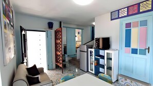 Een knus woongedeelte met kitchenette, een eethoek en een zithoek met een bank en een tafel.