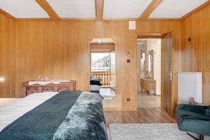 Une chambre à coucher aux murs lambrés, avec un lit, une commode et un miroir.
