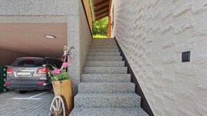 Eine Treppe führt zu einem Gebäude, in dessen Garage ein Auto geparkt ist.